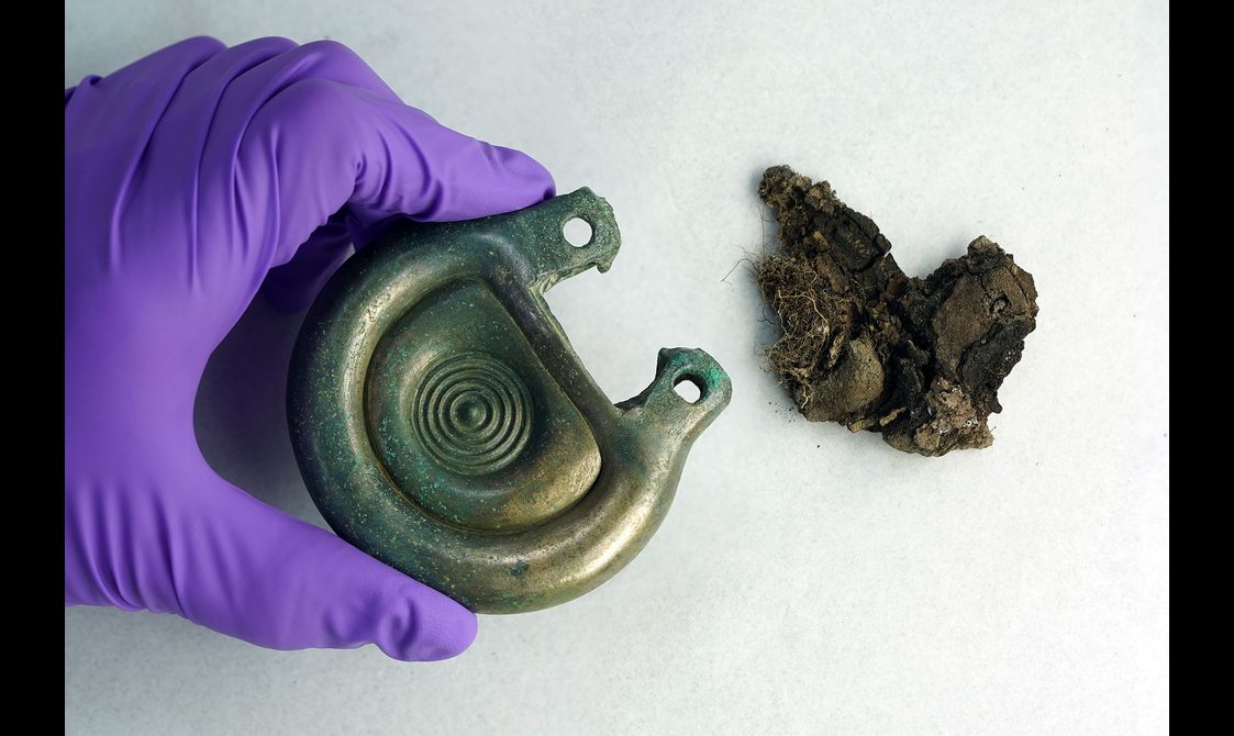A complete and preserved Peebles Hoard object next to mould fragments.
