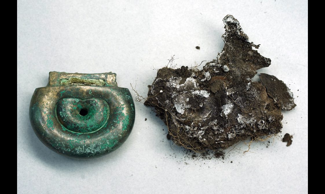 A complete and preserved Peebles Hoard object next to mould fragments.