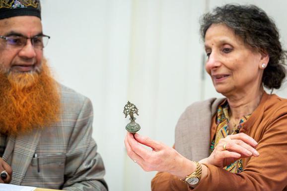Two people look at a kohl pot