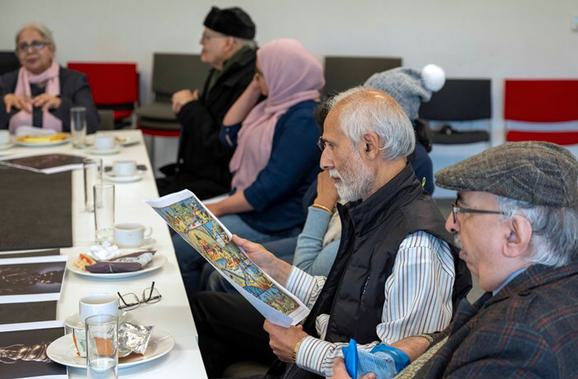 A person holds and examines a printed copy of the poster of Yama