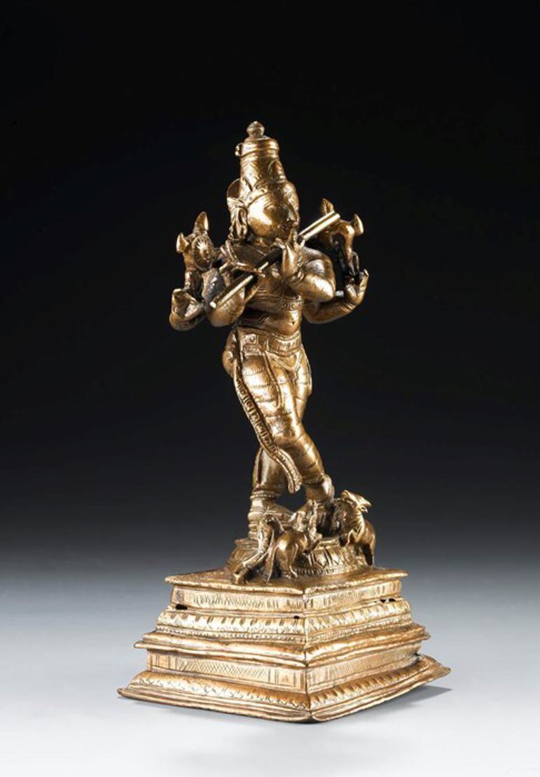 A gleaming brass statue of a figure playing a flute