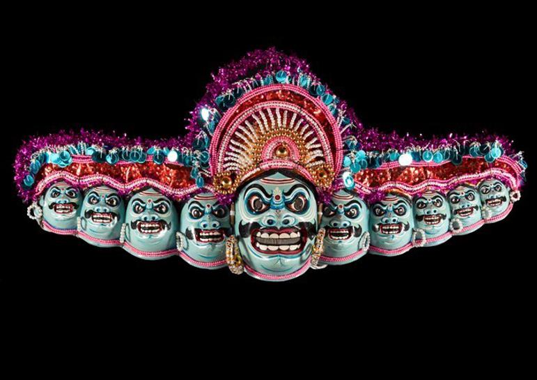 An elaborate, multi coloured mask comprised of ten faces