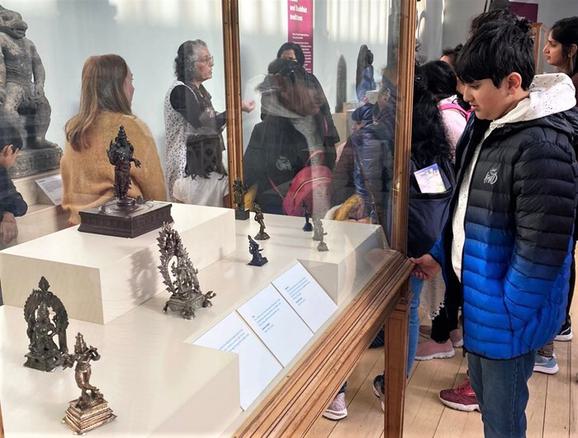A young person gazes at a case of metal figurines