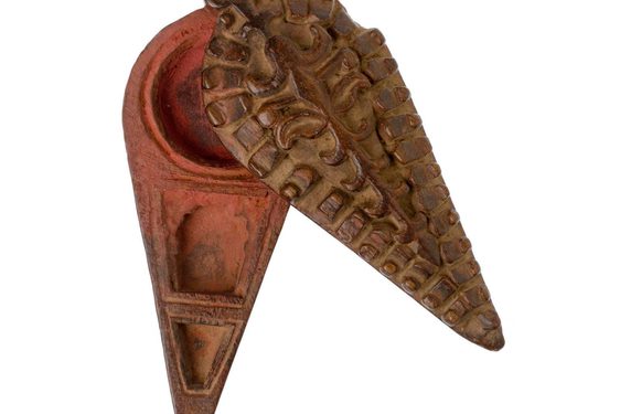 A small pot with a triangular handle, with a reddish coloured interior