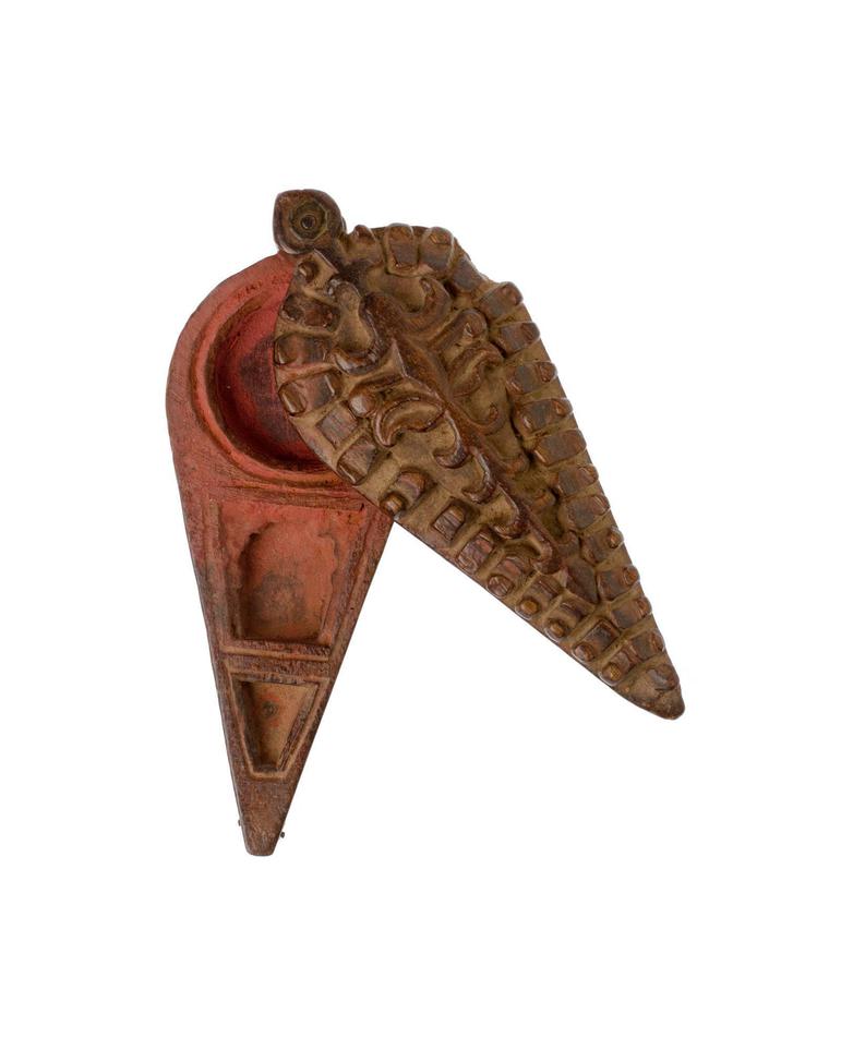 A small pot with a triangular handle, with a reddish coloured interior