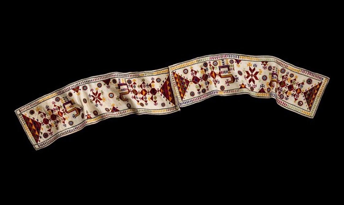 An ornately decorated cream and rust coloured scarf