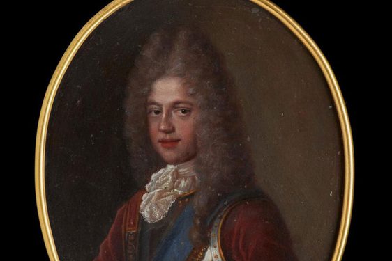 An oval-shaped miniature with gilded edges. A man wearing a long pointy grey curly wig, a red jacket, iron armor, white ruffled collar and a blue ribbon over left shoulder.