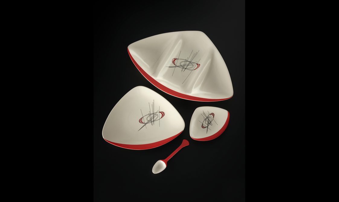 Orbit pattern triangular shaped earthenware segmented platter with rounded corners and one red flattened edge.