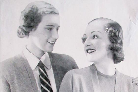 Black and white photograph of two women modelling Pringle of Scotland cardigans.