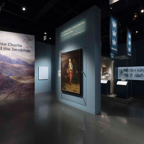 The entrance to the Bonnie Prince Charlie and the Jacobites, with a large painting on display and panels showing the Scottish highlands.