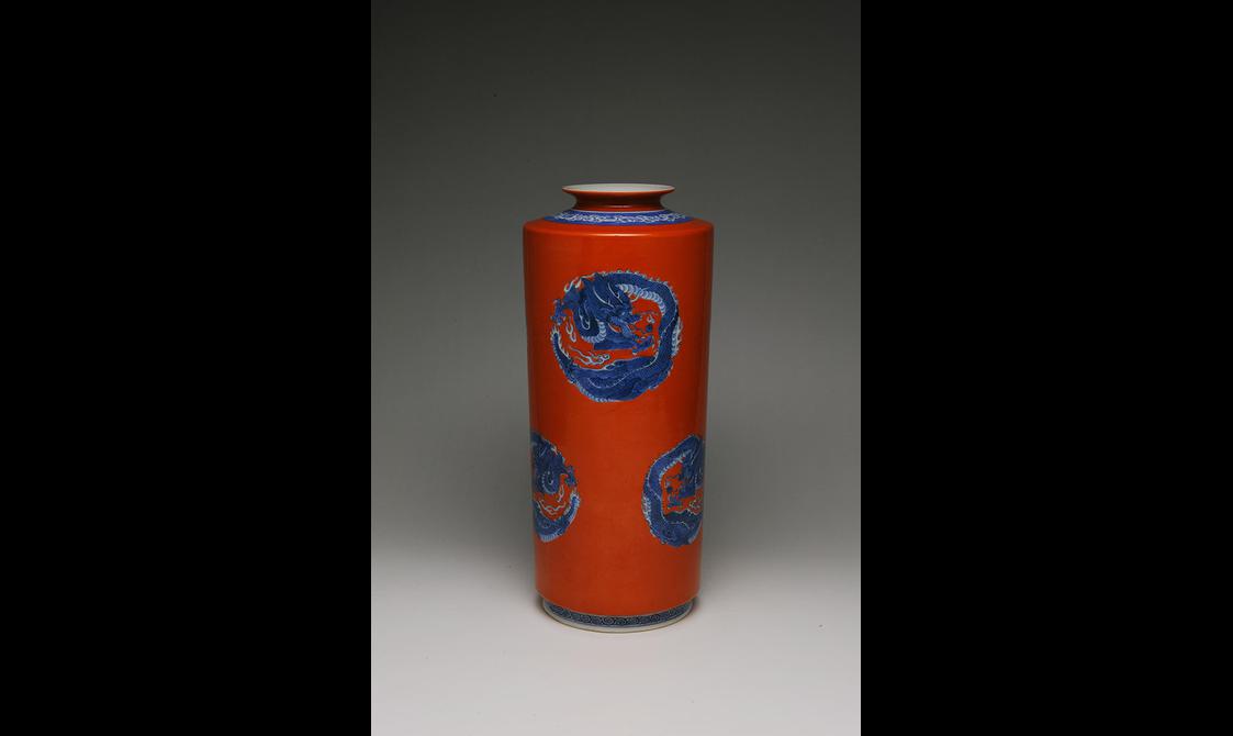 A red porcelain vase painted with blue dragons.