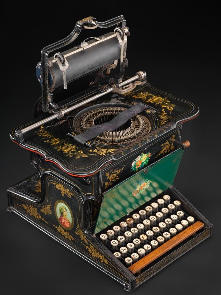 An old typewriter with elaborate paint designs.