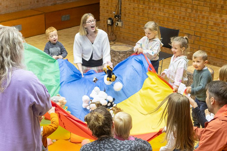 A group of children enjoy stories with a storyteller