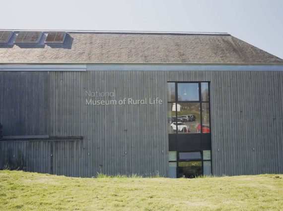 The outside of the National Museum of Rural Life. It is a large wood-paneled building with a runway to the entrance.