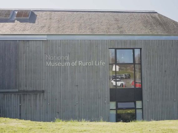 The outside of the National Museum of Rural Life. It is a large wood-paneled building with a runway to the entrance.