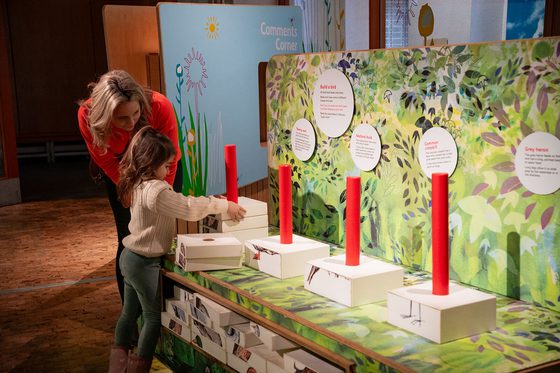 A parent and child play with animal puzzle blocks in the Garden Detectives gallery.