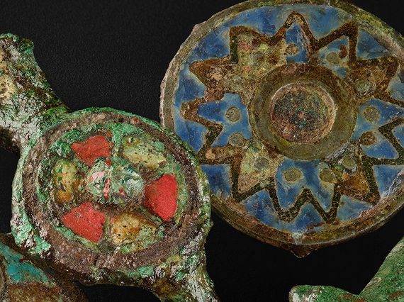 A collection of Roman brooches with colourful red and blue enamel
