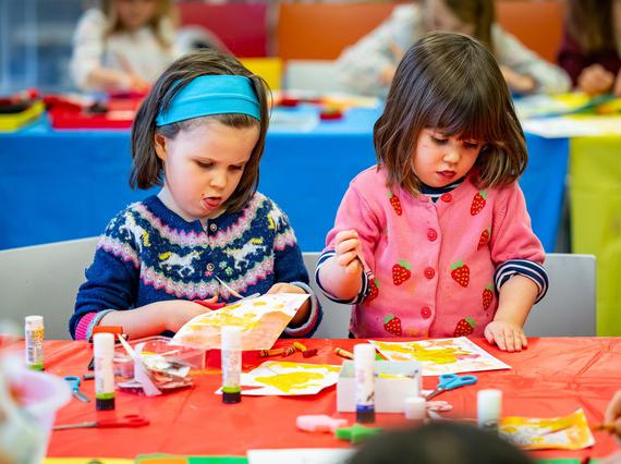 Two children doing crafts at a table.