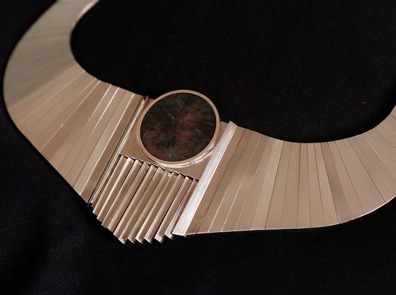 Close up of a gold necklace inset with a large red stone.