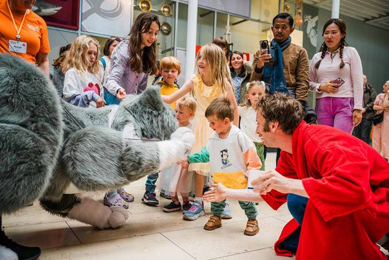 Children interact with a large cat puppet.