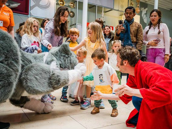 Children interact with a large cat puppet.