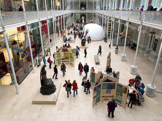 A busy museum gallery filled with people looking at boards and displays for the Edinburgh Science Festival