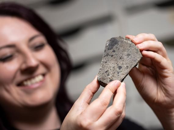 Close up of a curator holding a rock sample.