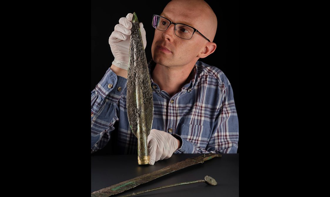Portrait of Dr Matt Knight with a Bronze Age spearhead