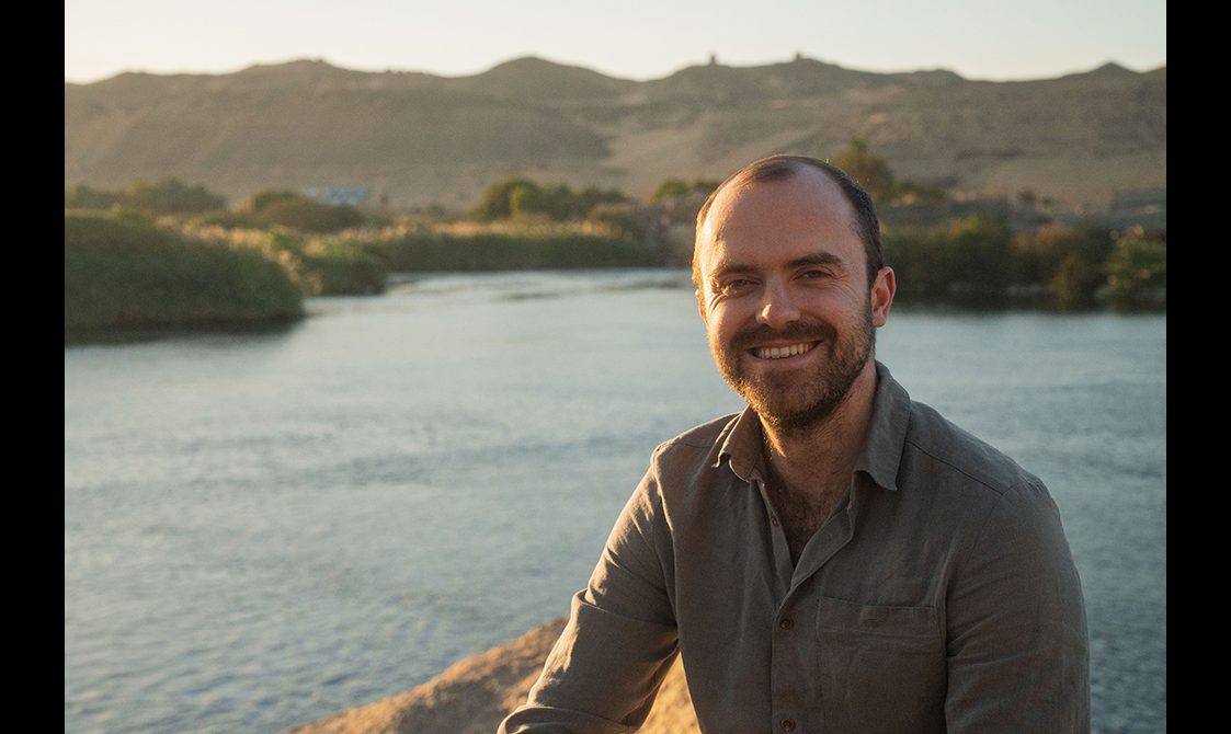 Portrait of Tristan Hughes pictured near a picturesque body of water.