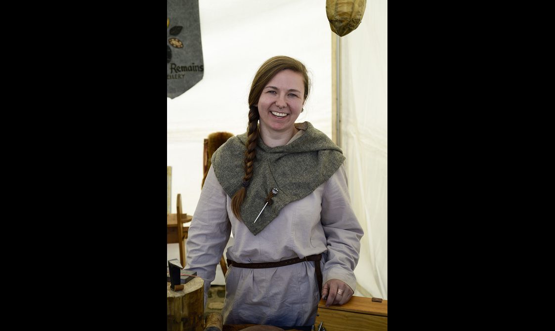 A woman with a dark plait wears Pictish clothing.