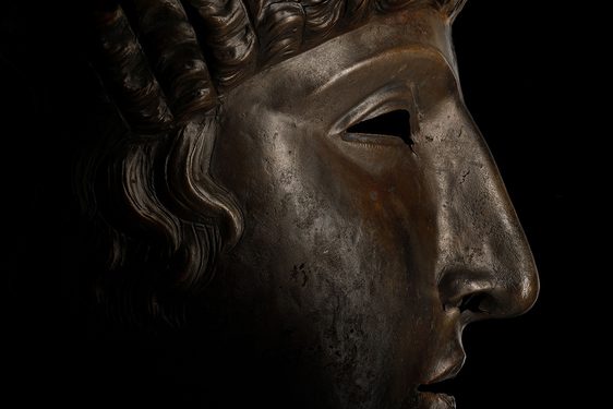 Side view of a bronze face mask