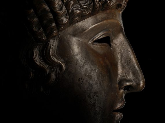Side view of a bronze face mask