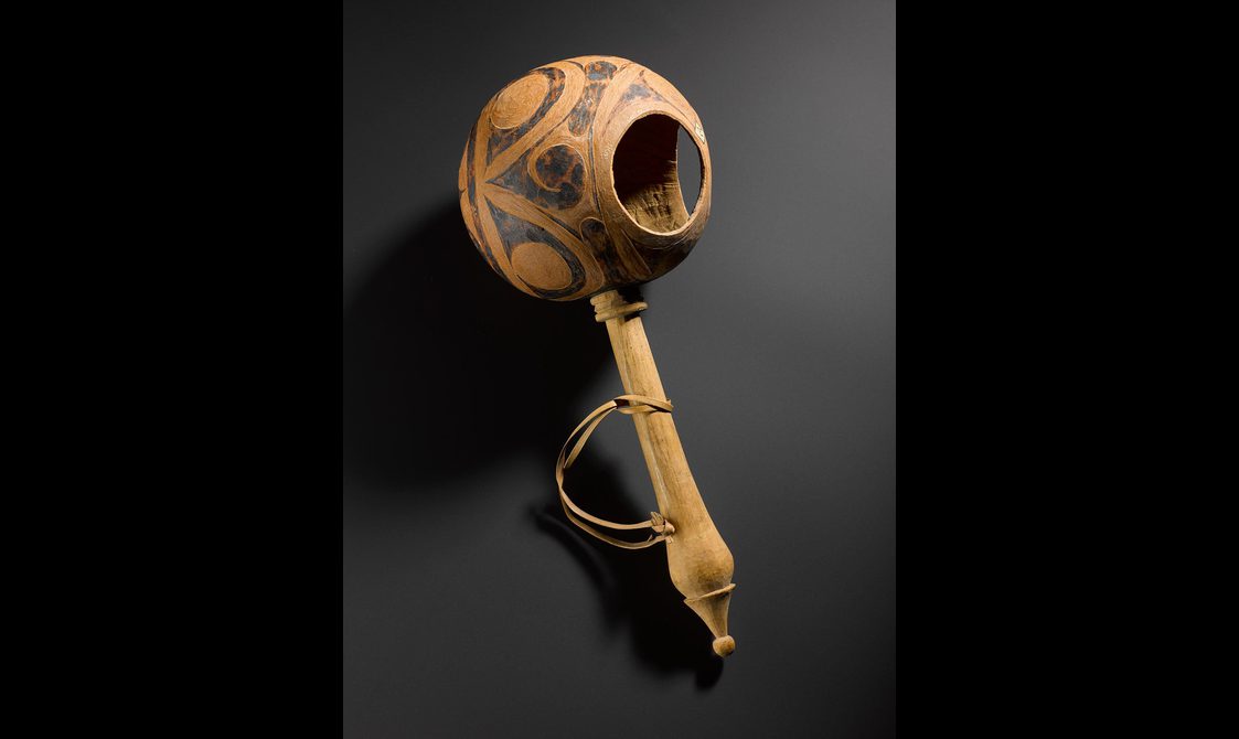 A wooden drinking cup with wooden handle.