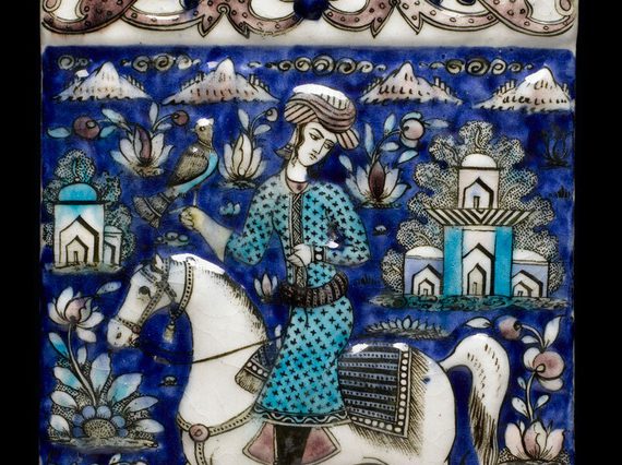 A blue, white and turquoise decorated wall tile showing a figure on a white horse with a bird of prey resting on his hand.