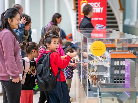 Young person points at a model of the museum made from Lego.