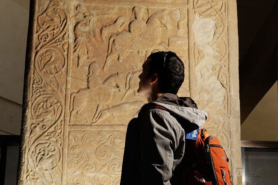 A visitor admires the Hilton of Cadboll stone, on display in Level -1 in the Early People gallery.