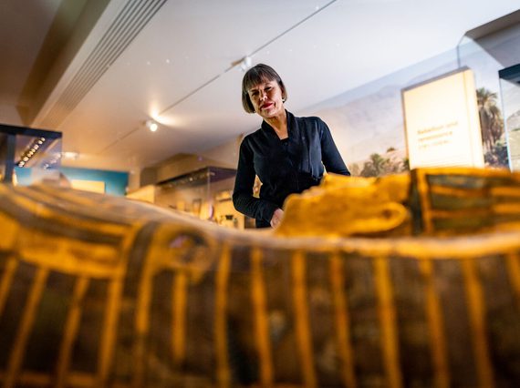 Visitor looking at a sarcophagus in the Ancient Egypt gallery.