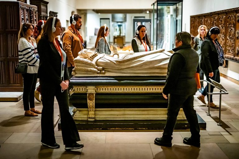 A tour group walk around the Mary Queen of Scots casket listening to an audio guide on headphones.