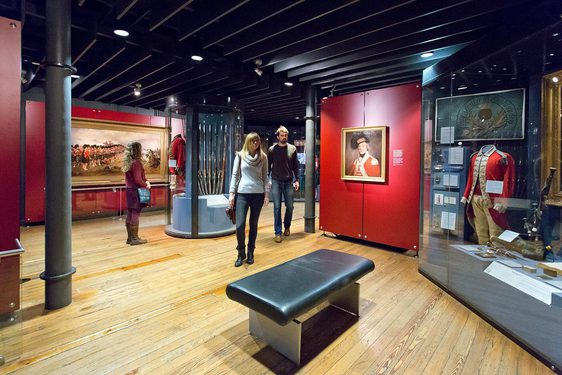 Three visitors look at displays in one of the galleries at the National War Museum.