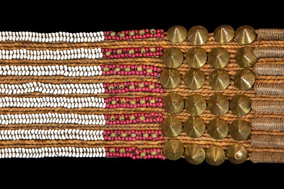 Intricately woven beaded belt with thin rows of white and red beads and spoked bronze studs.