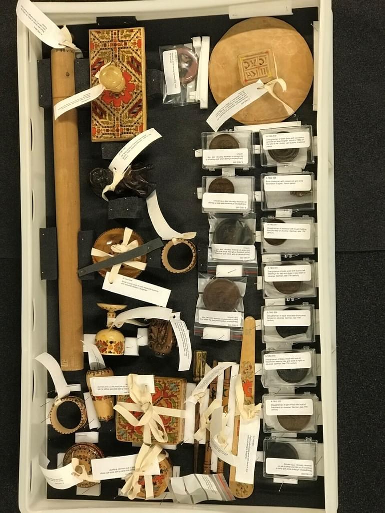A group of different museum objects packed together in a plastic box.