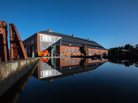 View of a museum building next to a body of water on a sunny day.