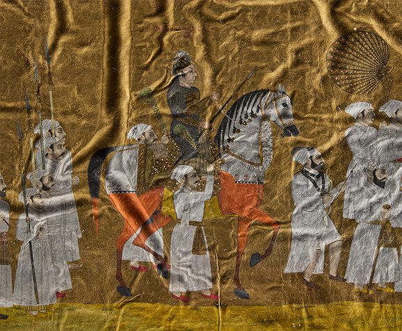 A crinkled gold painting close up of a man on horseback.