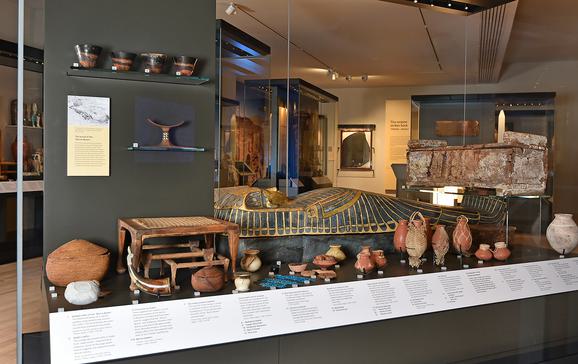 Several Ancient Egypt artefacts in a glass cabinet.
