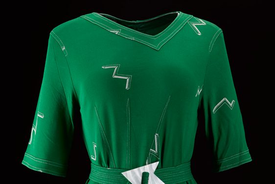 A green dress featuring a matching fabric belt with a white buckle.