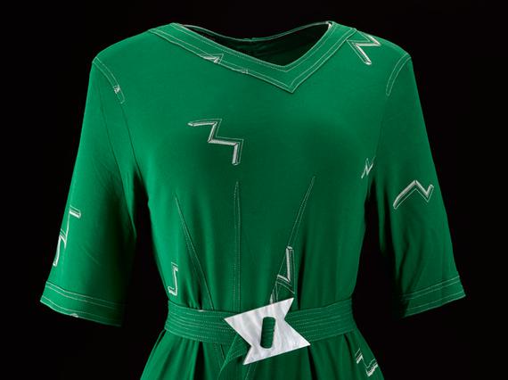 A green dress featuring a matching fabric belt with a white buckle.