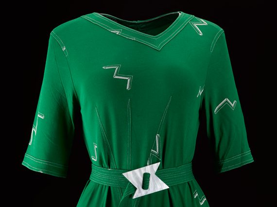 A green dress featuring a matching fabric belt with a white buckle.