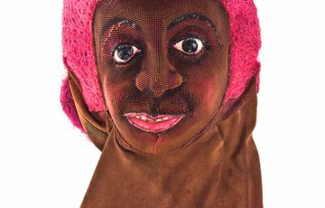 Face mask of a lady with pink hair.
