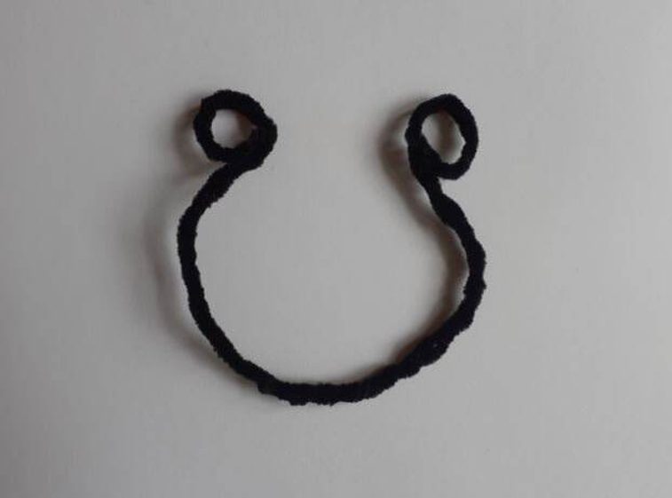 A black pipe cleaner bent into a curve with loops at each end.