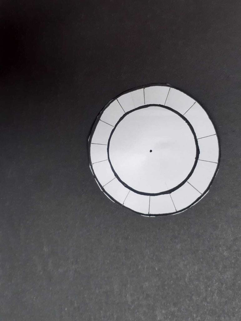 A paper circle with two drawn circles and 1.5 cm lines drawn on the outer circle.